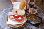 Typical lunch of salami/mozarella/tomato sandwich with cold beer